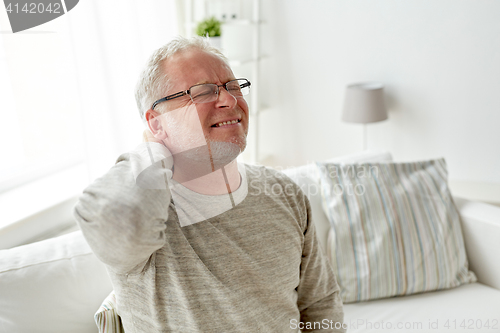 Image of senior man suffering from neckache at home