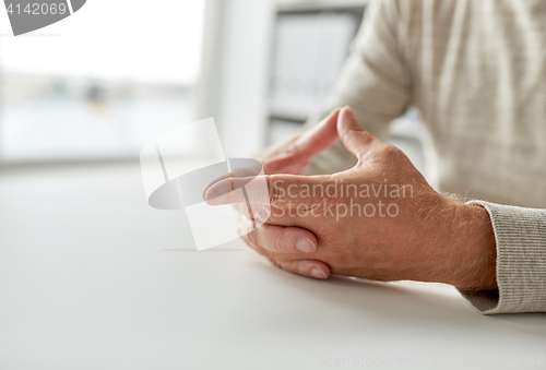 Image of close up of senior man hands on table