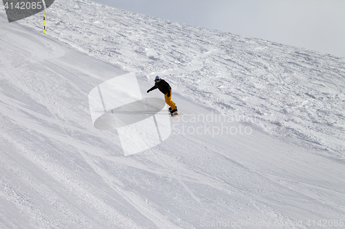 Image of Ski slope and snowboarder at winter cold day