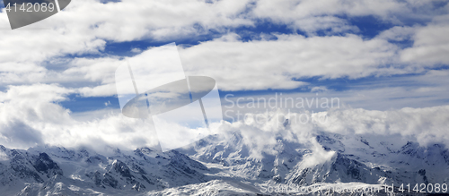 Image of Panoramic view on snow mountains and sunlight cloudy sky at wint