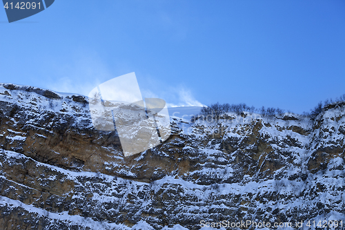 Image of Rocks in snow at wind winter evening