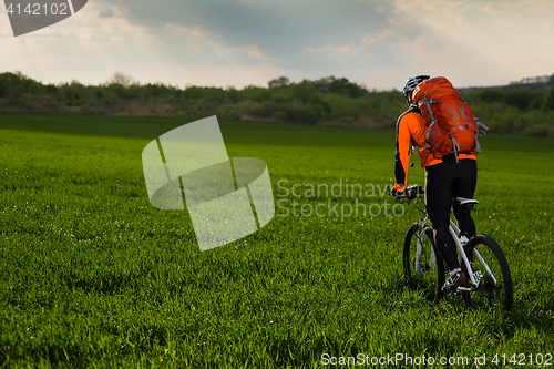 Image of Man Cyclist with bike on sunset