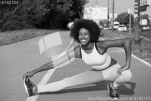 Image of Portrait of sporty young african american woman stretching outdo