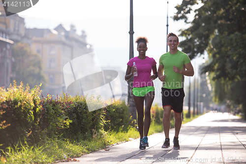 Image of young multiethnic couple jogging in the city