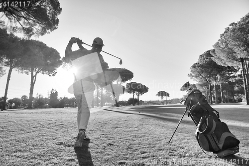 Image of golf player hitting shot with club