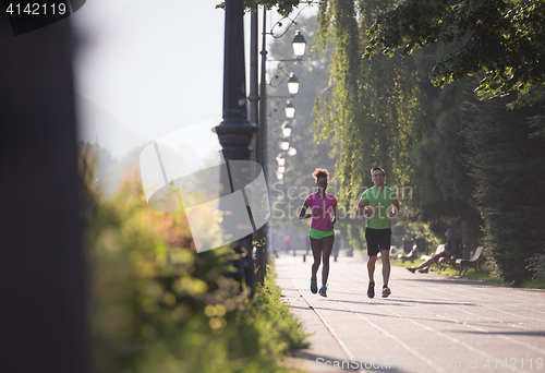 Image of young multiethnic couple jogging in the city