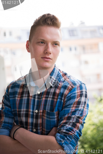 Image of man standing at balcony