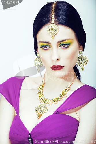 Image of young pretty caucasian woman like indian in ethnic jewelry close up on white, bridal makeup