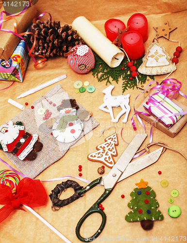 Image of handmade christmas gifts in mess with toys, candles, fir, ribbon, post card view decorated