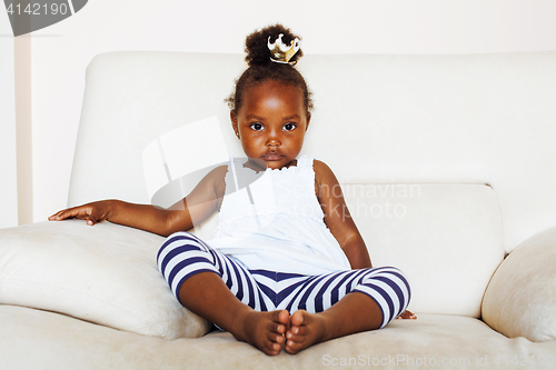 Image of little pretty african american girl sitting in white chair weari