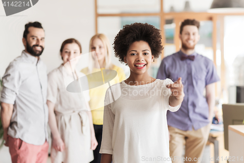 Image of woman pointing to you over creative office team