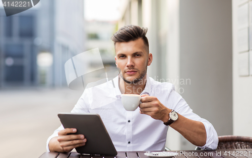 Image of man with tablet pc and coffee at city cafe