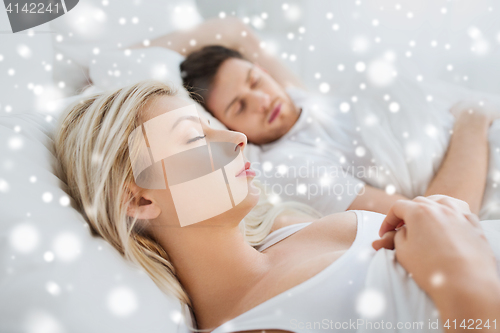 Image of happy couple sleeping in bed at home