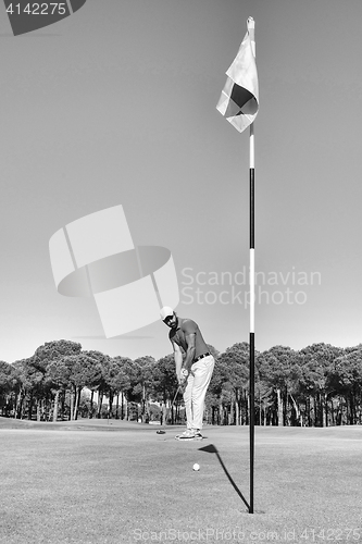 Image of golf player hitting shot with club on course