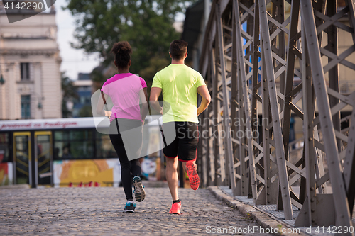 Image of multiethnic couple jogging in the city