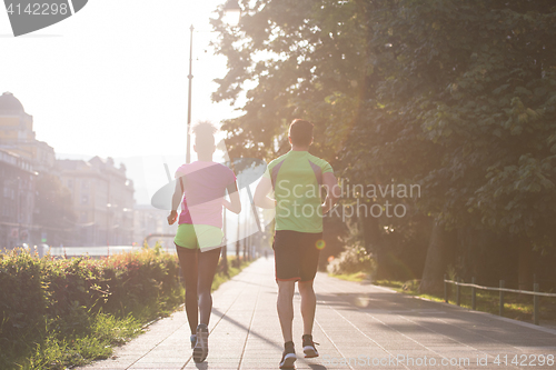 Image of young multiethnic couple jogging in the city