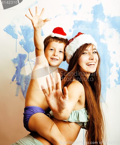 Image of funny family in red hats celebrating new year, mother with son happy smiling, lifestyle people concept