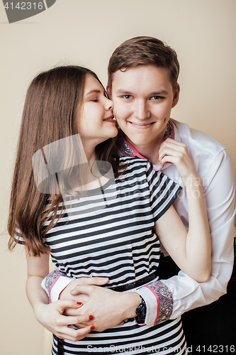 Image of couple of happy smiling teenagers students, warm colors having a kiss, lifestyle people concept