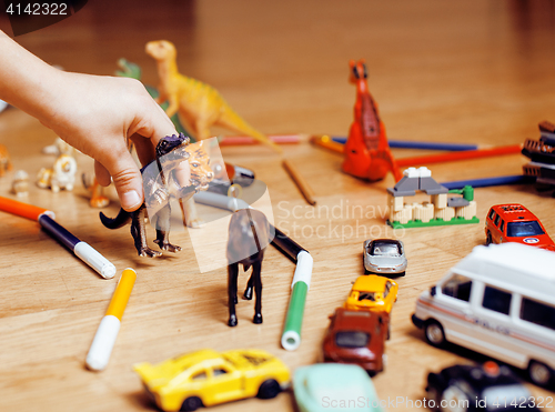 Image of children playing toys on floor at home, little hand in mess, free education