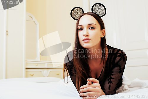 Image of young pretty brunette woman wearing sexy lace mouse ears, laying