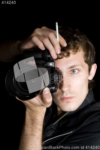 Image of The young man - photographer behind work. Isolated on a black ba