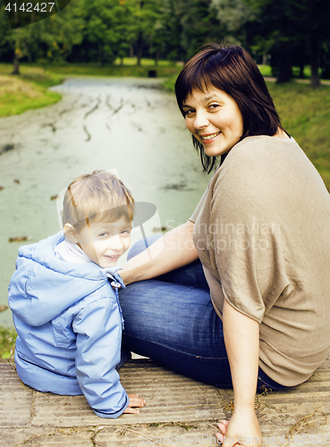 Image of mature woman with little boy outside, mother with son in green p