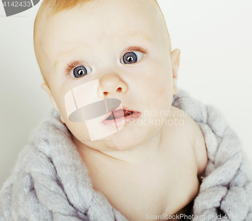 Image of little cute red head baby in scarf all over him close up isolate