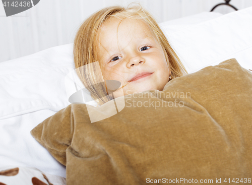 Image of little cute blonde norwegian girl playing on sofa with pillows, 