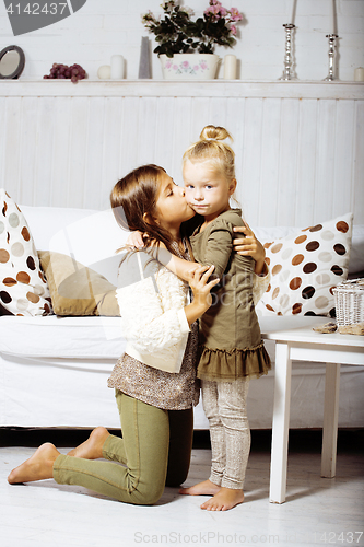 Image of two cute sisters at home playing, little girl in house interior