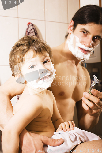 Image of Portrait of son and father enjoying while shaving together