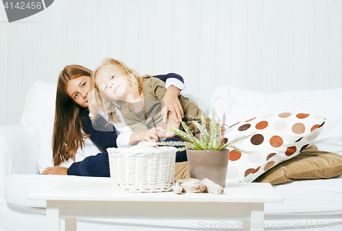 Image of two cute sisters at home playing, little girl in house interior 