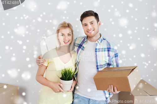 Image of smiling couple with boxes moving to new home