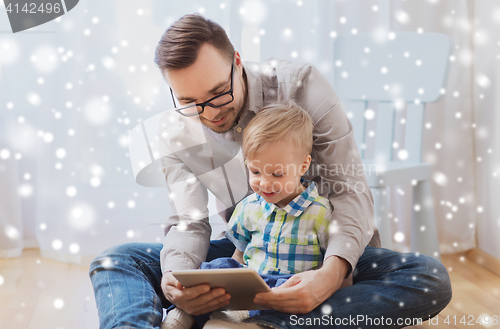 Image of father and son with tablet pc playing at home