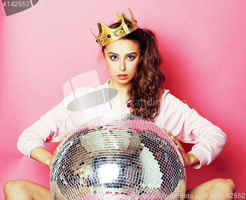 Image of young cute disco girl on pink background with disco ball and cro