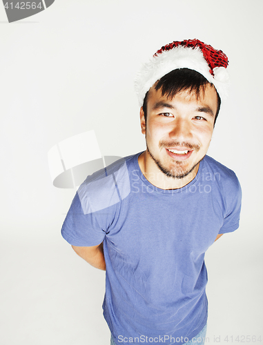 Image of funy exotical asian Santa claus in new years red hat smiling