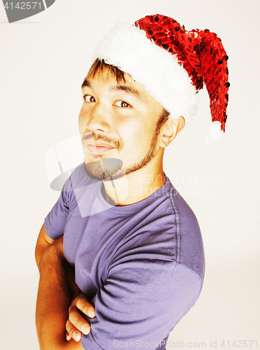 Image of funy exotical asian Santa claus in new years red hat smiling