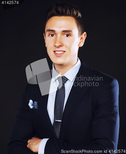 Image of young pretty business man standing on black background, modern h