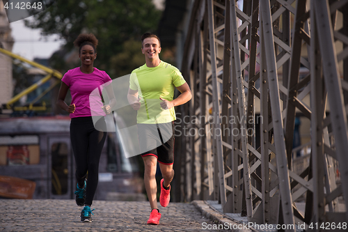 Image of multiethnic couple jogging in the city