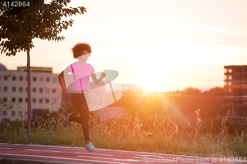 Image of a young African American woman jogging outdoors