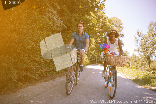 Image of Young multiethnic couple having a bike ride in nature