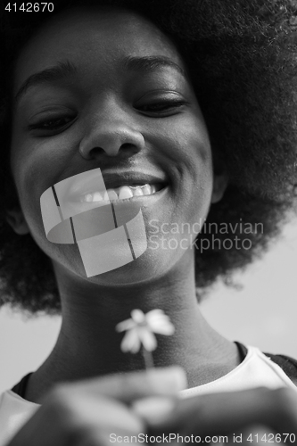 Image of portrait of African American girl with a flower in her hand