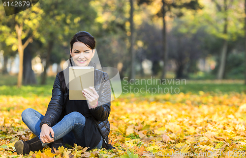 Image of Woman with a Tablet in a Forest in the Autumn