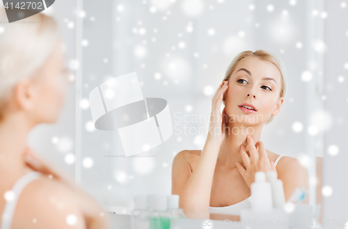 Image of happy young woman looking to mirror at bathroom