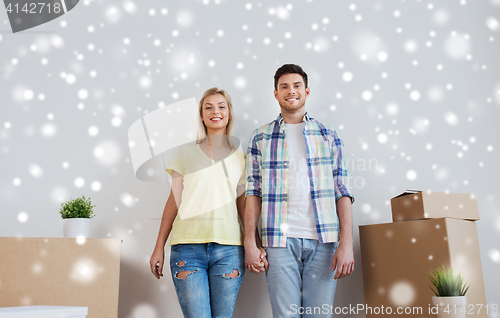 Image of smiling couple with big boxes moving to new home