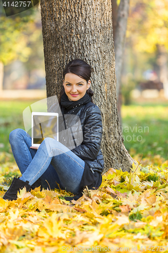 Image of Woman with a Tablet in a Forest in the Autumn