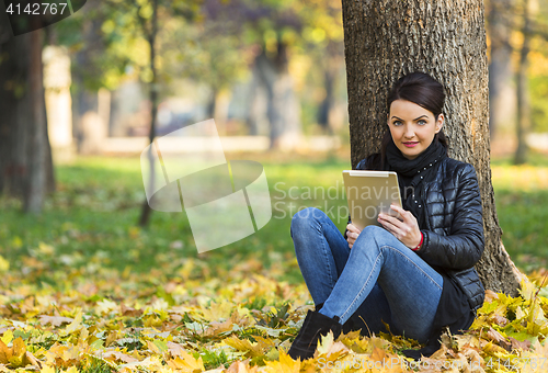 Image of Woman with a Tablet in a Forest in the Autumn