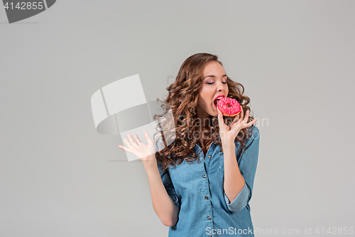 Image of The smiling girl on gray studio background with round cake