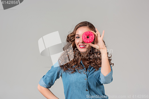 Image of The smiling girl on gray studio background with round cake