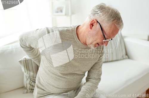 Image of unhappy senior man suffering from backache at home