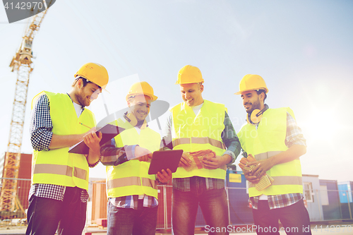 Image of group of smiling builders with tablet pc outdoors